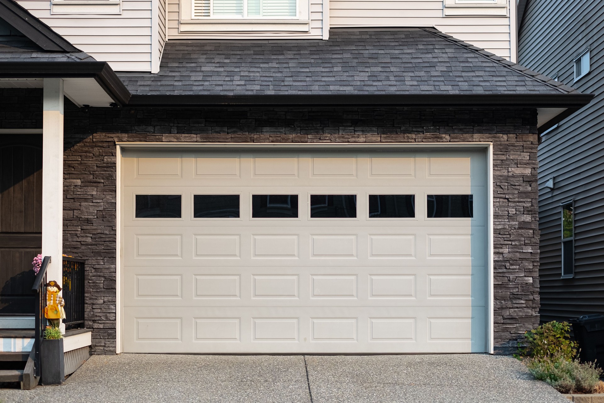 Porte de garage. Maison moderne avec porte de garage fermée. Un quartier parfait. Maison familiale avec large porte de garage